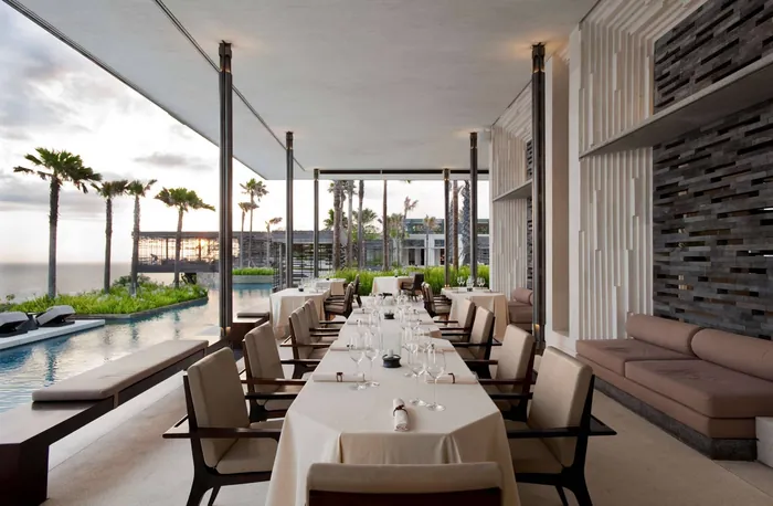 Alila Villas Uluwatu Cire Restaurant at sunset overlooking the clifftop pool