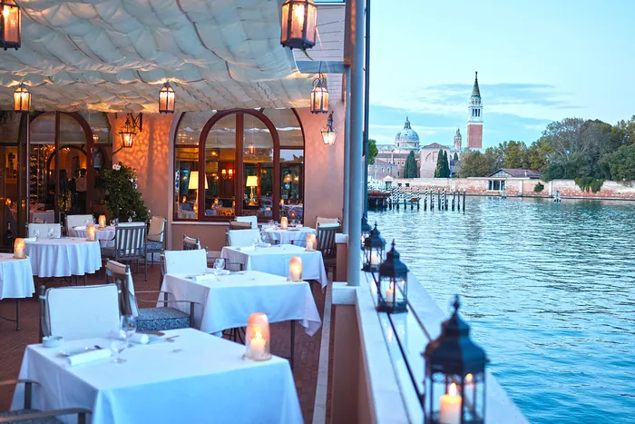 Hotel Cipriani Cip's Club floating terrace at dusk with candlelit tables