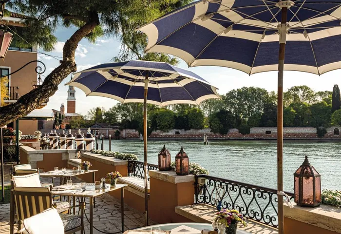 Hotel Cipriani Cip's Club lagoon terrace with blue parasols and canal view