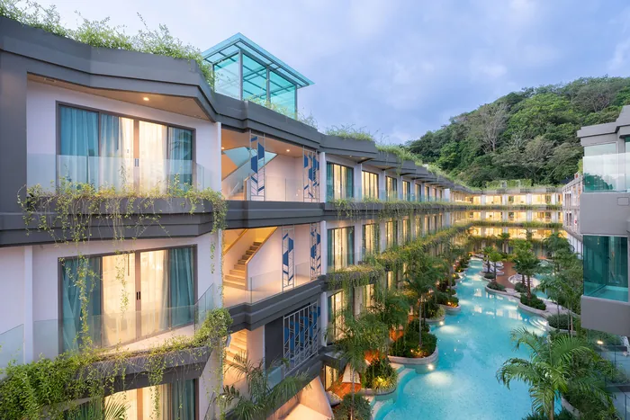 Panwaburi Resort Phuket exterior at dusk with balconies and illuminated lagoon pool