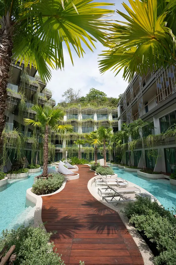 Panwaburi Resort Phuket lagoon pool courtyard with wooden walkway and palm trees